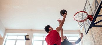 two men playing a game of basketball on a court